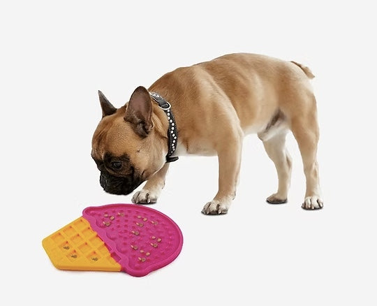 French Bull Dog eating from a lick mat.