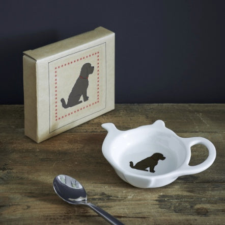 white ceramic teabag dish with a brown Oodle dog on it.