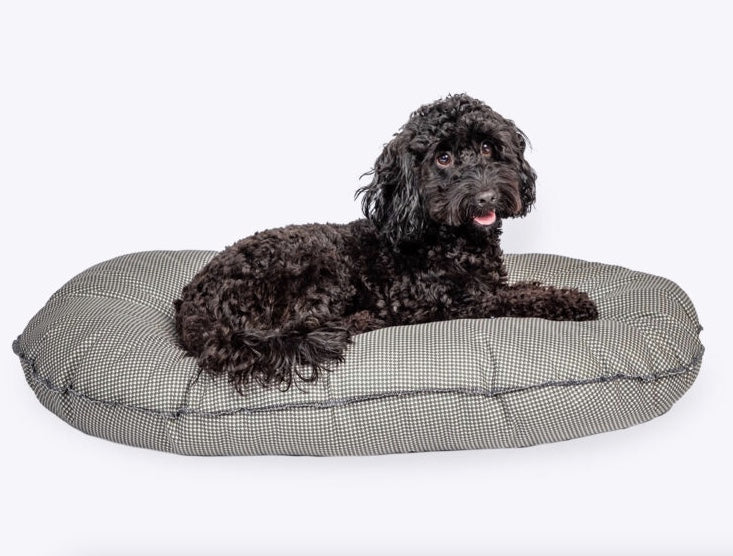 Small black dog lying on the Vintage Dogstooth Dog Mattress