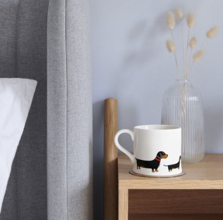 Ceramic mug with a Dachshund on the side of it.
