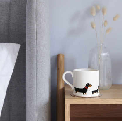 Ceramic mug with a Dachshund on the side of it.