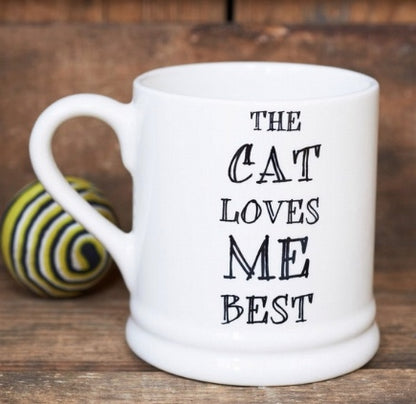 Porcelin mug with The Cat Loves Me Best printed on it.