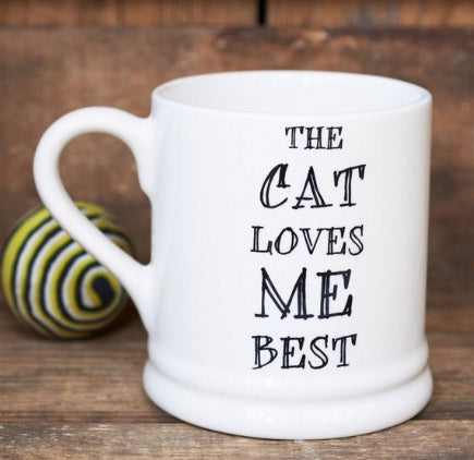 Porcelin mug with The Cat Loves Me Best printed on it.